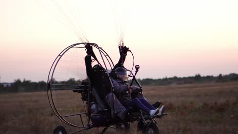 el parapente de motor despega con una chica y un hombre en el aeropuerto acelerando y despegando en el cielo en paracaídas
