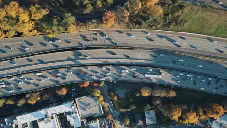 Dron-De-Arriba-Hacia-Abajo-Con-Panorámica-Lenta-Mientras-Los-Autos-Conducen-Rápidamente-En-Las-Curvas-Para-Ir-A-Casa-Después-Del-Trabajo