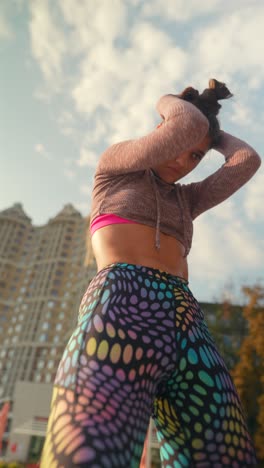 mujer en ropa de deporte posando al aire libre
