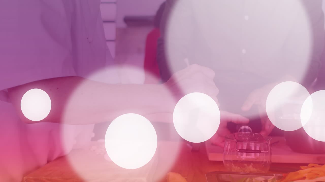Home cooks placing garlic cloves on board, chopping and feeding dough into pasta maker making pasta