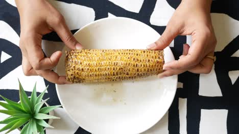 Mujeres-Sosteniendo-Una-Mazorca-De-Maíz-En-Un-Plato,