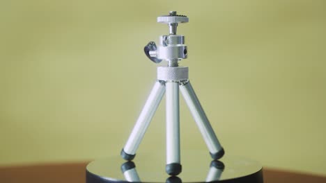 mini tripod, silver metallic on a rotating stand 360, slow motion, 4k