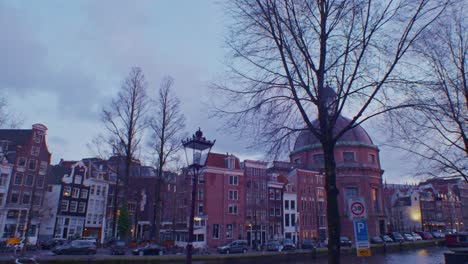 amsterdam dutch city town of netherlands europe in the evening with beautiful traditional houses buildings and canal while walking with wide angle view