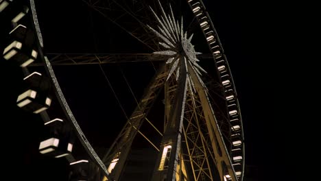 the famous budapest eye ferris wheel during evening - tilt up shot