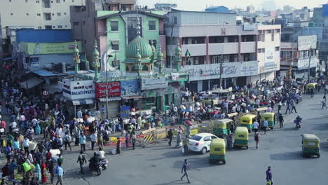 Bustling street market scene in KR Market area with mosque and auto-rickshaws in Bangalore India