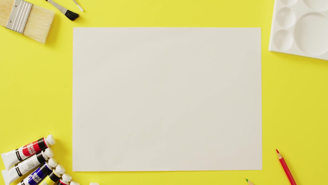 Video of empty sheet with copy space, pencils and brushes on yellow background