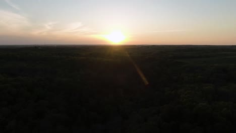 Langsam-Ansteigende-Neigungsaufnahme-über-Einem-Sehr-Dunklen-Wald-Während-Eines-Späten-Sonnenuntergangs-In-Wisconsin