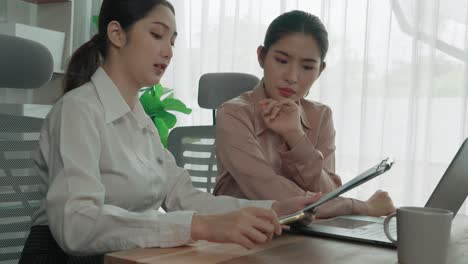 Two-young-enthusiastic-businesswoman-working-together-in-the-office-workspace.