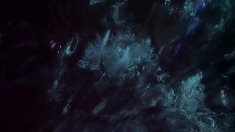 details of an abstract shot of frozen air bubbles inside the icy cavern of a glacial ice cave in iceland