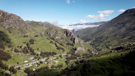 awesome drone shot in between green and rocky mountains in the highlands of the andes