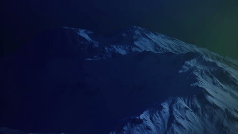 snow covered mountain peak illuminated by northern lights at night