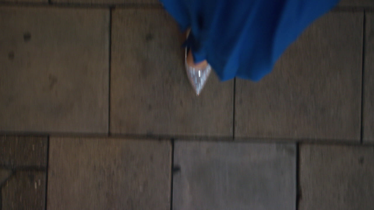 mujer caminando por la acera vistiendo elegante vestido de fiesta de noche elegantes zapatos brillantes paseando por la vida nocturna de la ciudad urbana