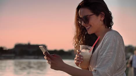 chica usando un teléfono móvil en el lago
