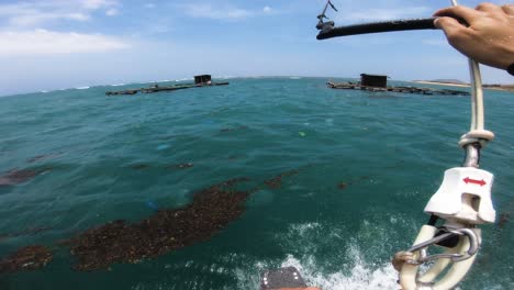 kitesurfing in trash polluted sea in vietnam floating fishing farms, pov