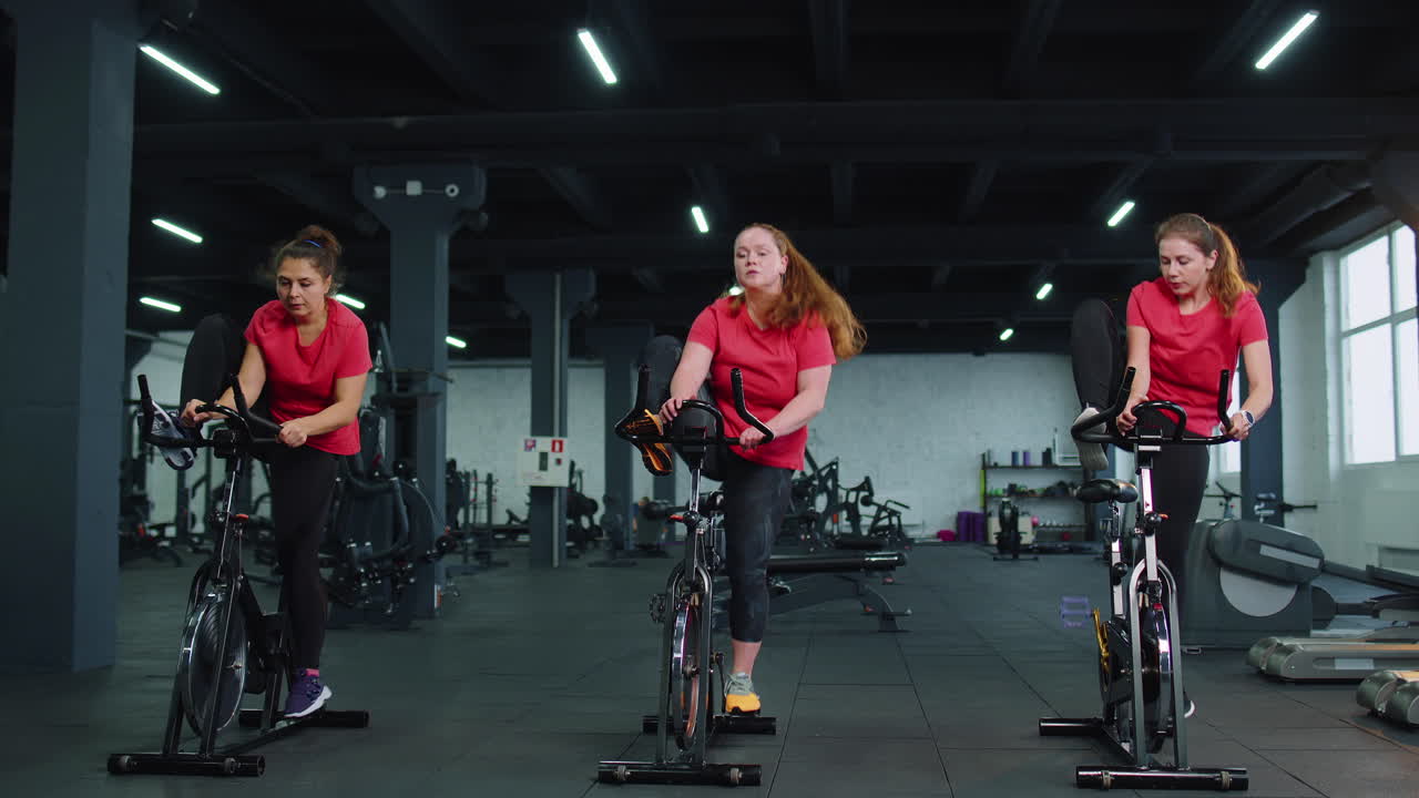 운동 여성 그룹이 스피닝 스테이션 자전거를 타고 체육관에서 훈련, 실내에서 체중 감소