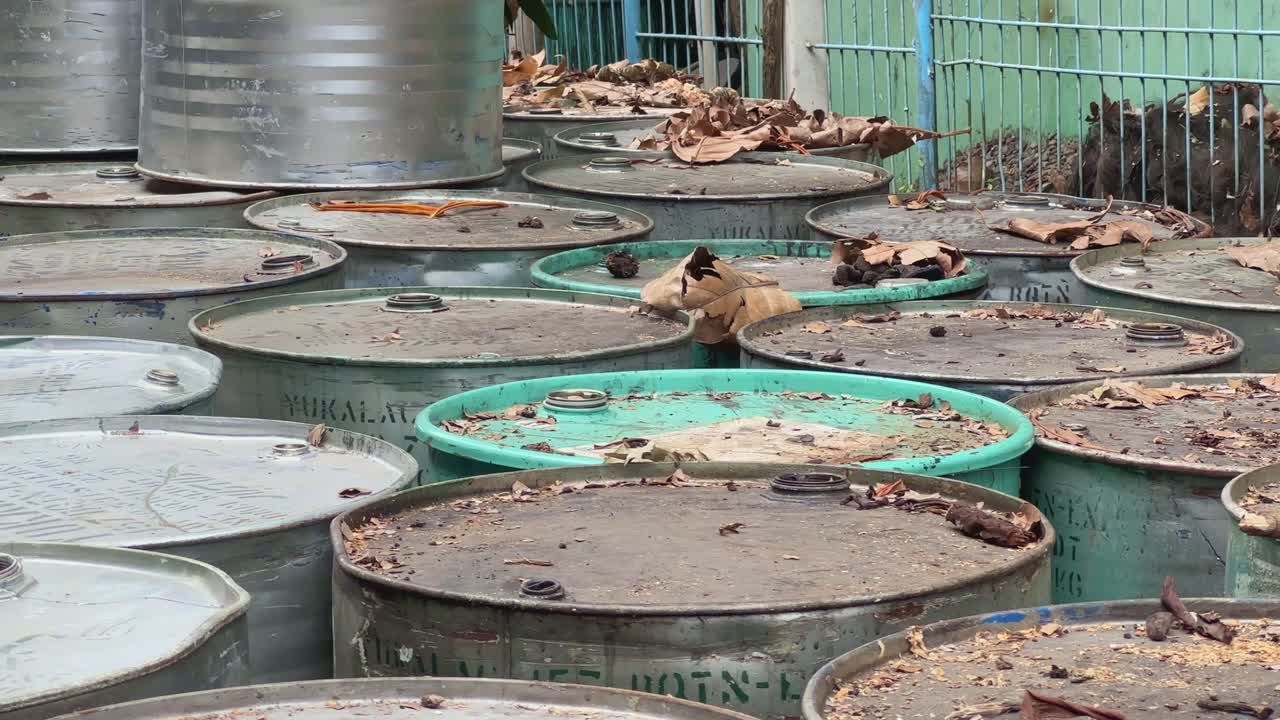 Close-up shot of abandoned barrels of chemical waste on a site.