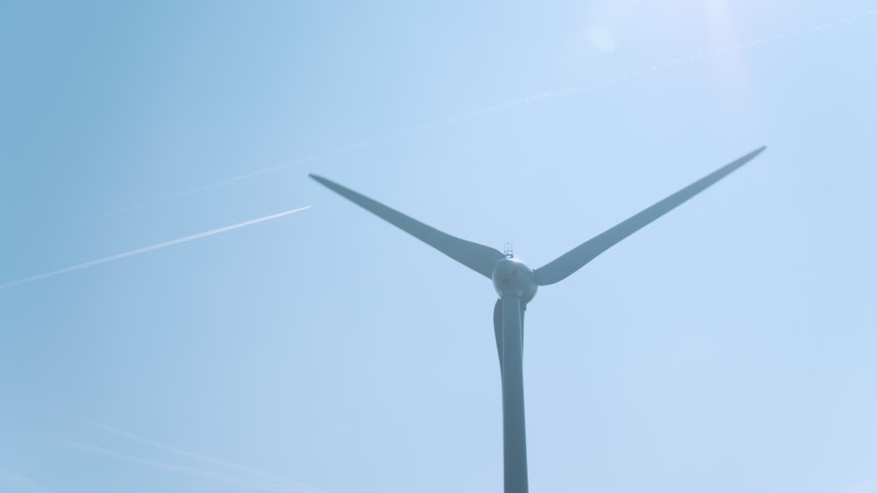 풍차 터빈 드론 돌리 배경에 비행기 트레일과 함께 파란 하늘을 향해