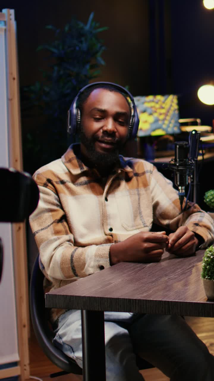 Vertical video Guest amused by talking show host telling jokes, recording with high tech equipment