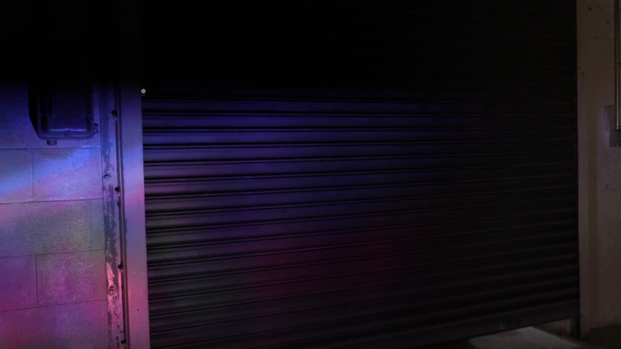 Partier Dressed in Dark Clothing Walking Through a Warehouse Rave Party