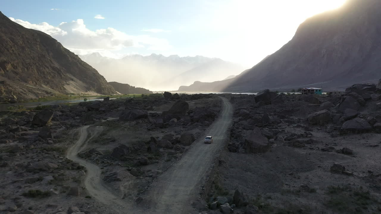 fotografía de un vehículo que conduce por un camino de tierra en el valle de skardu, pakistán