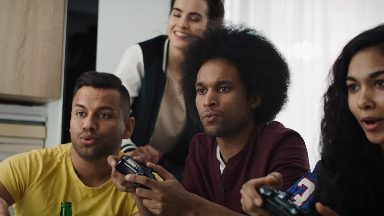 Tilt up video of excited friends playing on game console