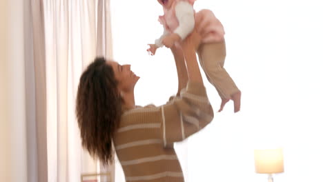 madre feliz lanzando al bebé emocionado en el aire