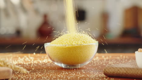 pouring golden grains into a glass bowl
