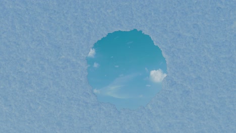 animation of circular mirror reflecting passing white clouds and surrounded by snow. flat lay of winter style concept