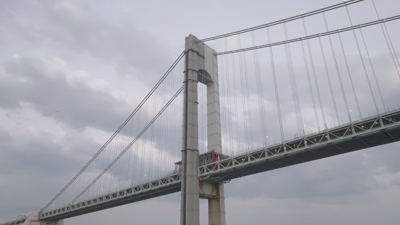 Drone shot looking up at the Verrazzano-Narrows Bridge on an overcast day. Shot in New York City