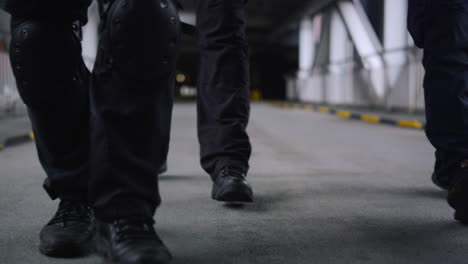 closeup swat police officers' legs walking in urban building