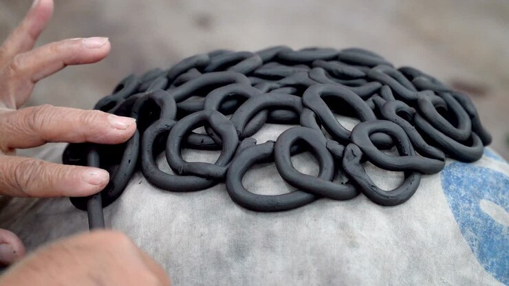 produzione tradizionale di ceramica, close up delle mani del ceramista che modellano una ciotola sulla filatura con l'argilla