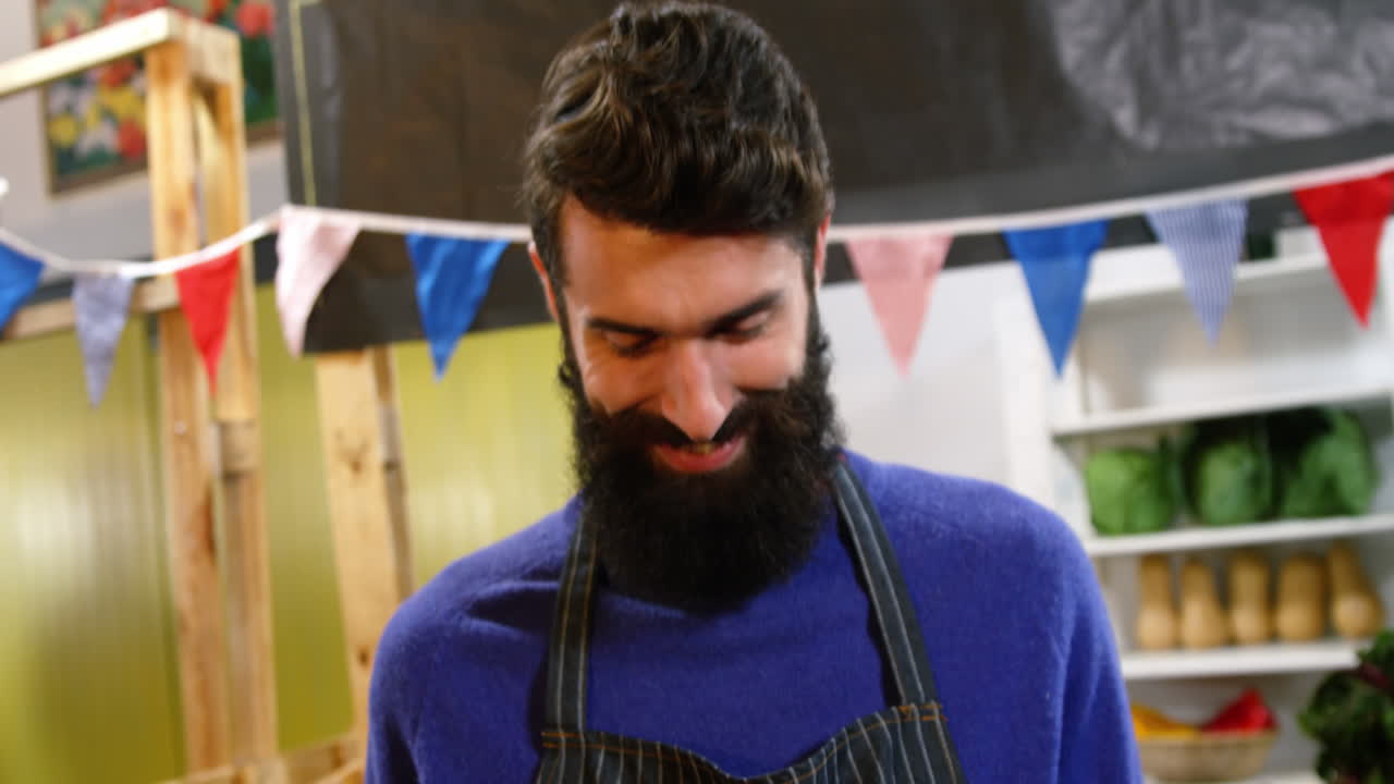 el personal masculino sonriente sosteniendo una caja de verduras frescas en el supermercado