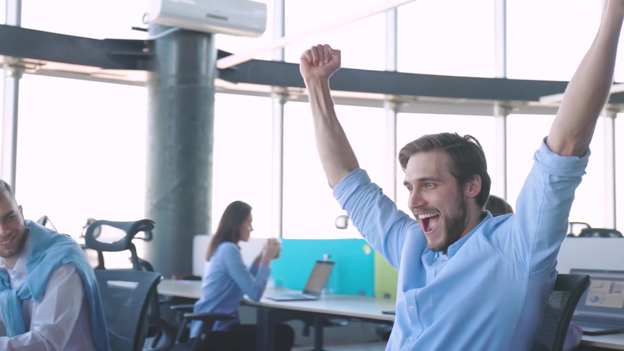 Giovane imprenditore felice che festeggia il successo in un ufficio moderno