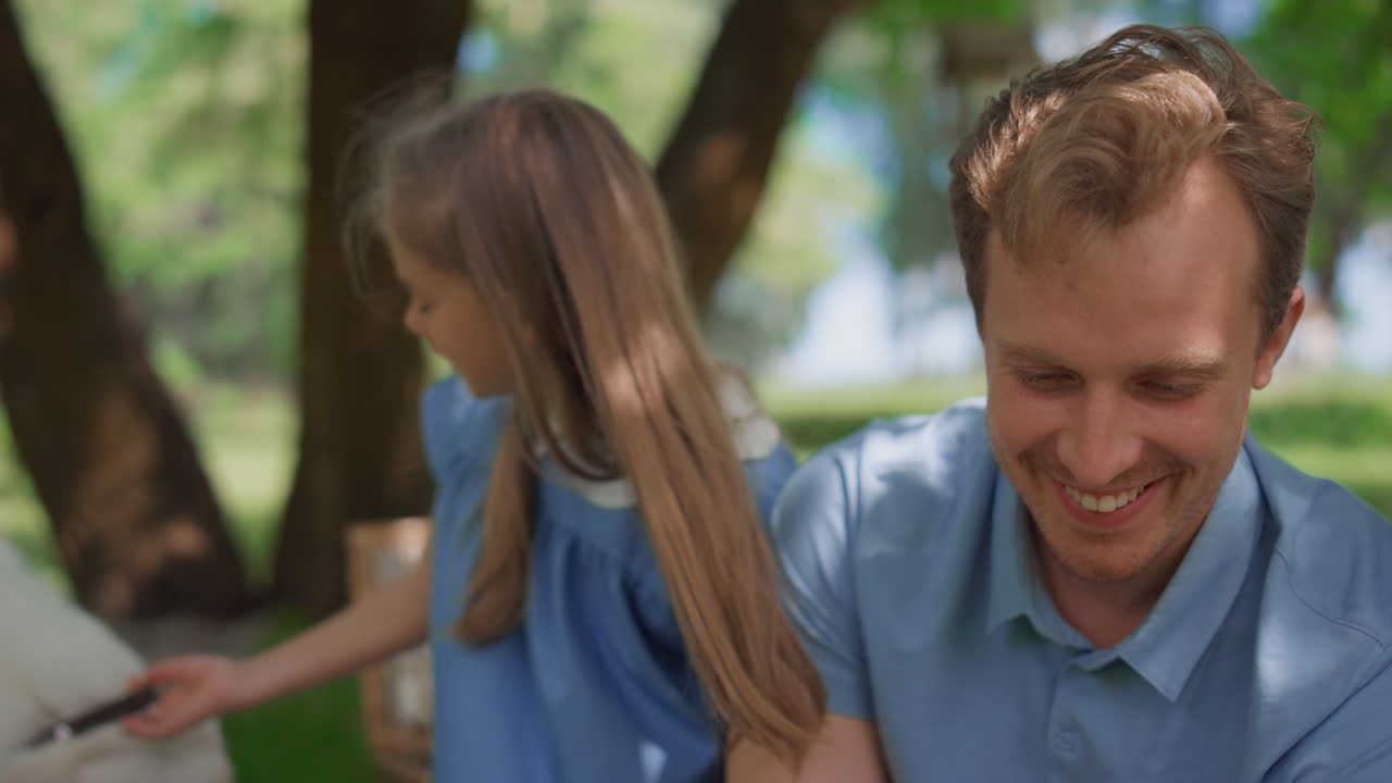 태블릿 클로즈업으로 자연에서 즐거운 가족 휴식. 공원에서 재미있는 부모.