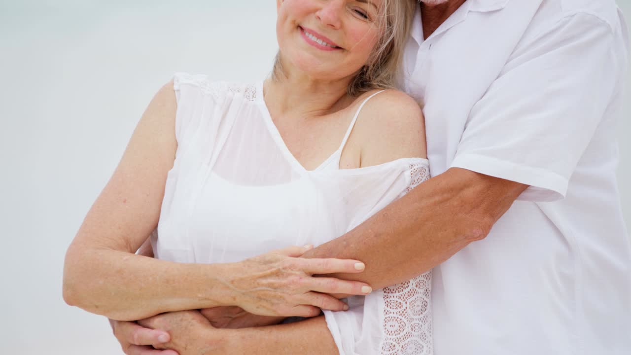 섬의 해변에서 만적인 고위 백인 커플