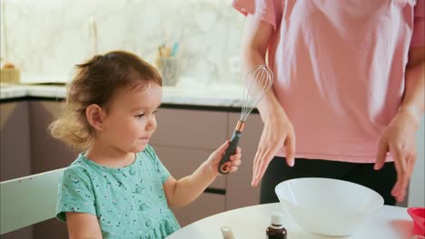 joyful learning in the kitchen: a child's culinary adventure with mom, mixing ingredients and sharing laughs in a family bonding moment