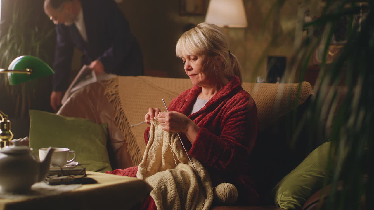 Elderly woman knitting in a cozy living room