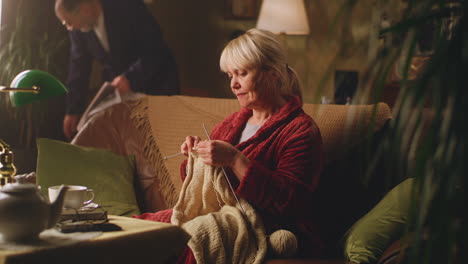elderly woman knitting in a cozy living room