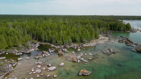 aerial ascent of bush bay wilderness forested rocky beach on lake huron, michigan