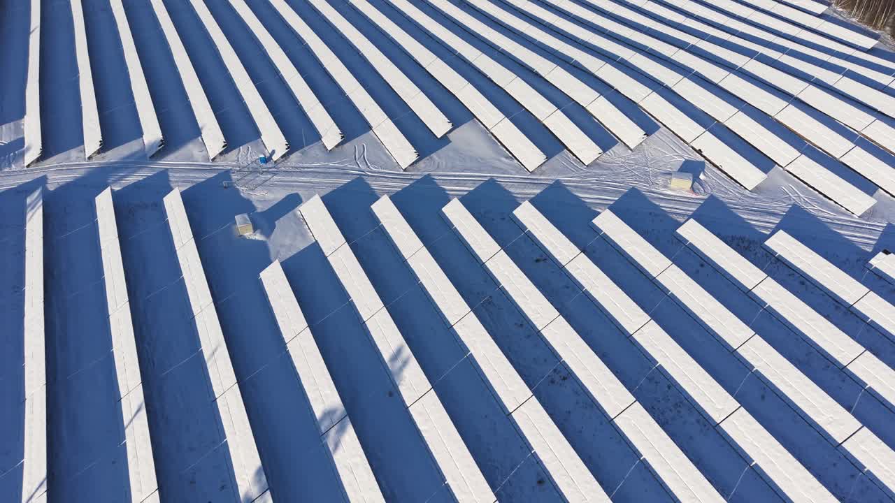 Vista aérea de paneles solares cubiertos de nieve en un sereno paisaje invernal