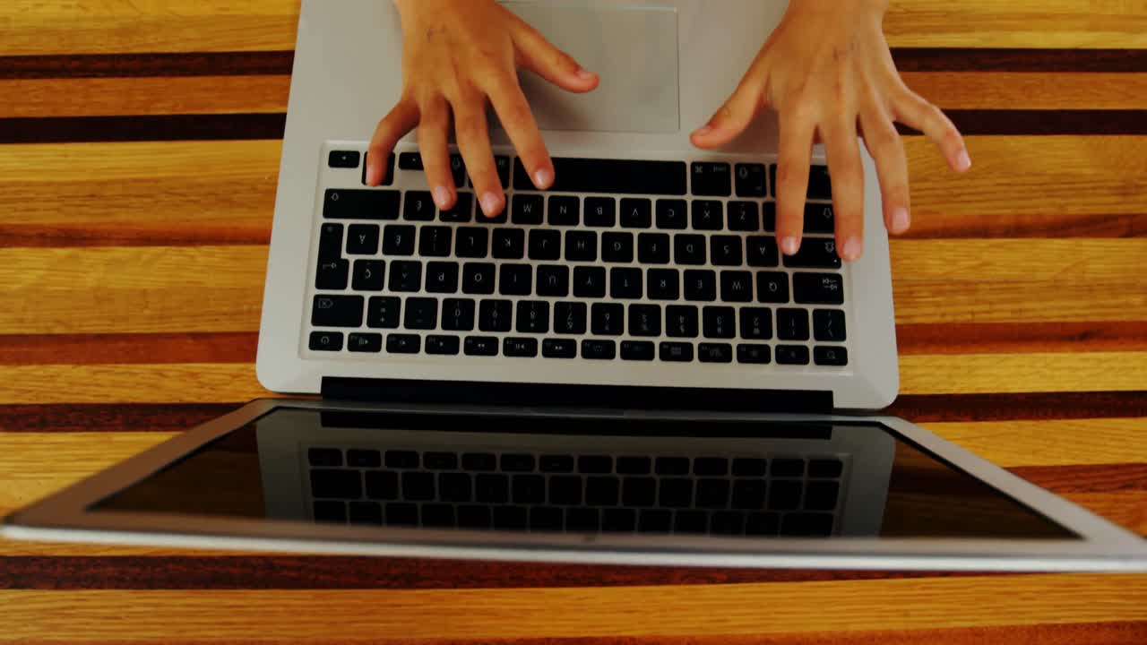 de manos de un niño usando una computadora portátil en la mesa