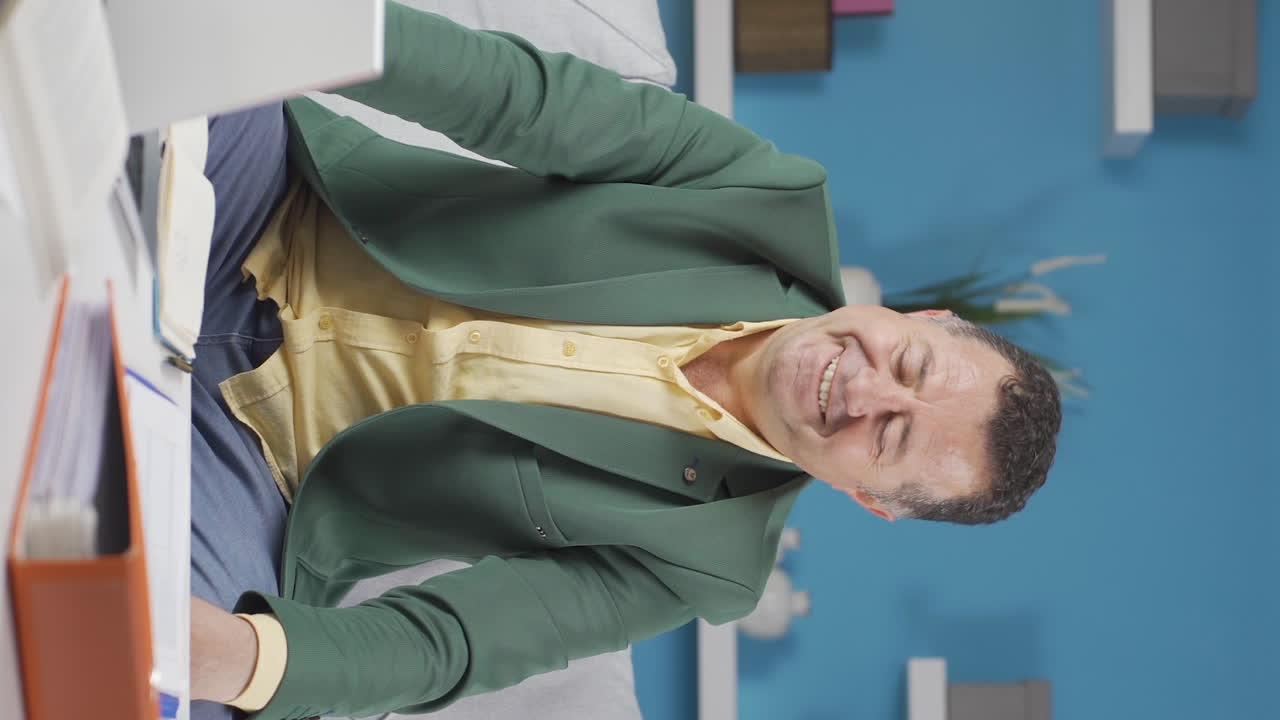 vídeo vertical de un anciano trabajador de la oficina de casa feliz y alegre.