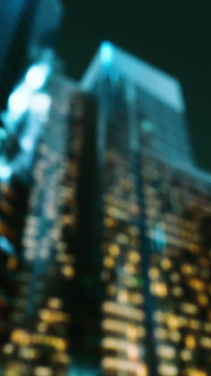 una foto borrosa de un edificio alto en la ciudad por la noche