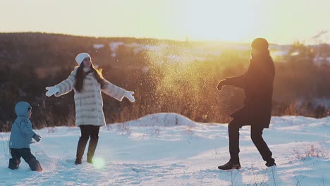 la gente feliz toma nieve blanca y la arroja contra el atardecer de invierno.