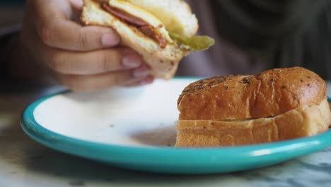 una persona comiendo un delicioso sándwich de desayuno