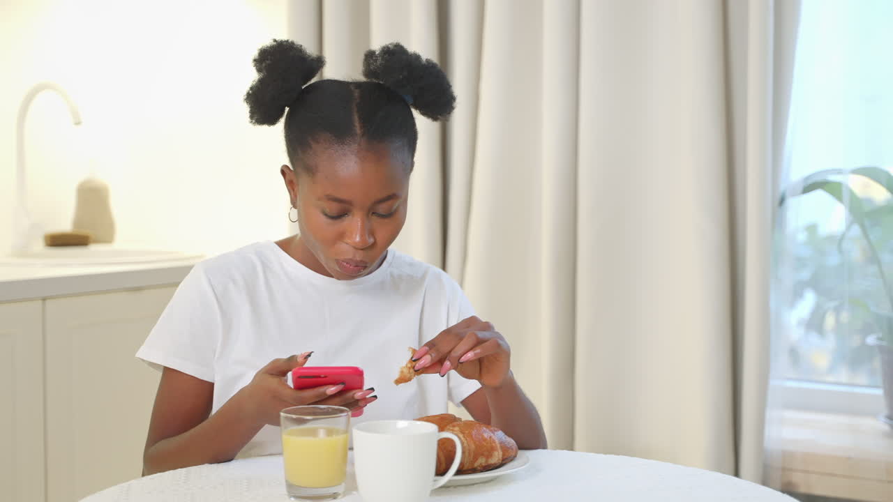 chica desayunando y usando su teléfono inteligente