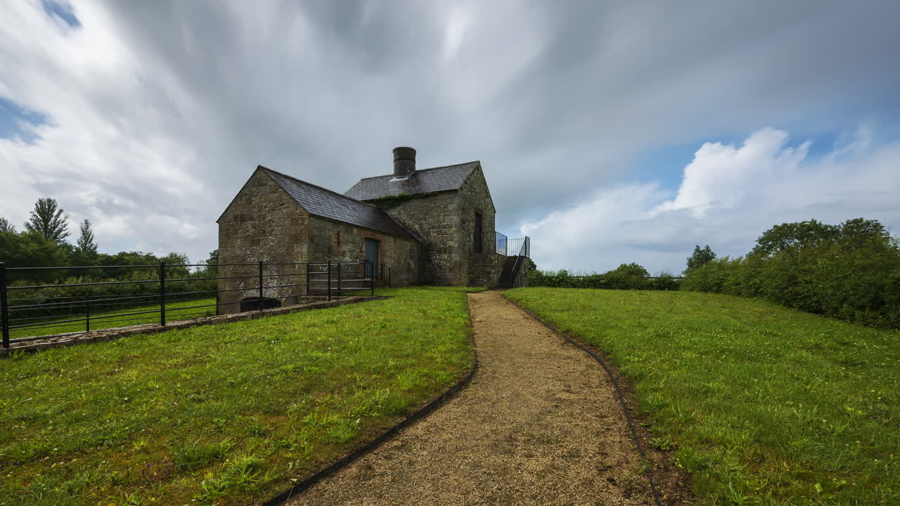 lapso de tiempo de un edificio histórico de horno de cal durante el día con nubes pasajeras en el paisaje rural de irlanda