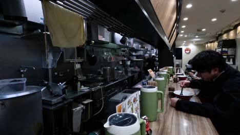 man enjoying ramen at a restaurant counter