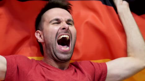 german fan celebrating while holding the flag of germany in slow motion ,4k , high quality