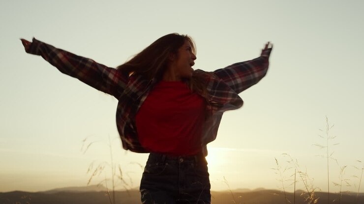 Donna che si diverte in montagna al tramonto